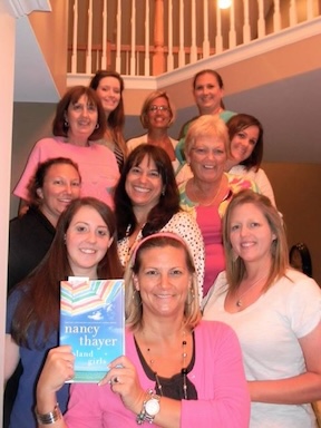 A group of women on a stair case with the book Island Girls.