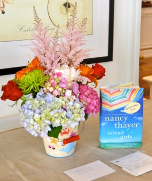 A colorful flower arrangement next to a copy of Island Girls