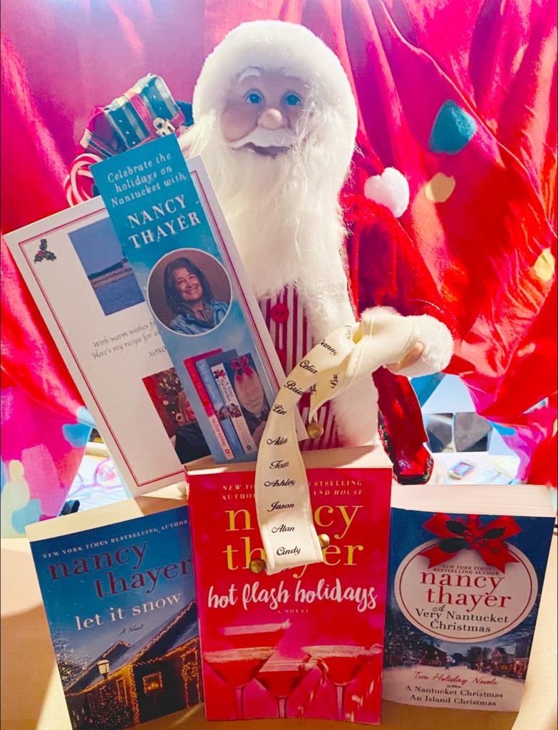 Three Nancy Thayer Christmas books with Santa in the background.