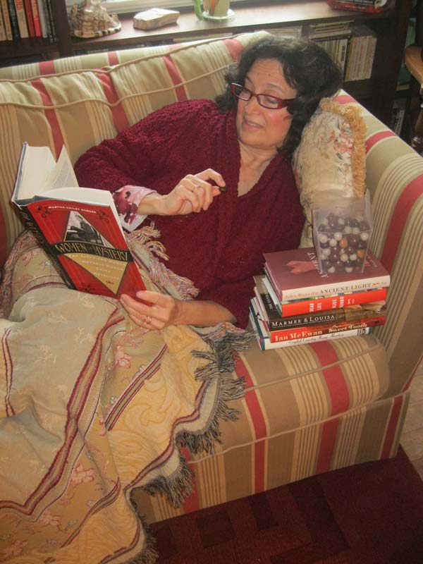 nancy-on-the-couch Women in glasses reading books on the couch.